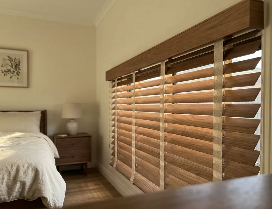 Warm timber venetian blind with wide slats and fabric ladder tapes in a Hazelwood bedroom